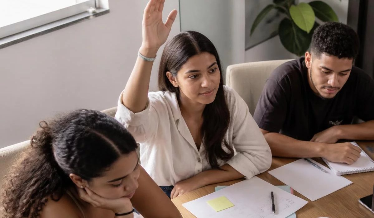 Duas pessoas preparando a próxima rodada com caderno e marca-texto na mão